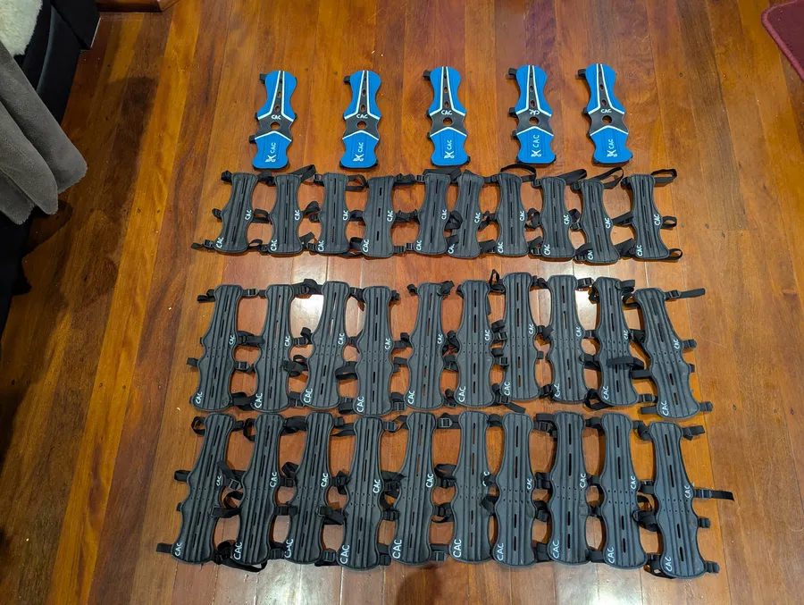 Ten arm guards laid out on a floor, photographed by a verified buyer